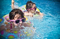 度假儿童在游泳池学习游泳